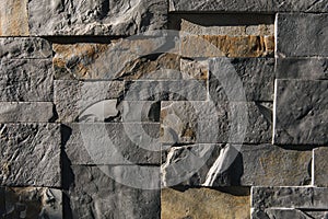 Stone wall in sunlight. Sharp shadows emphasize the textere. Different size cut out gray marble wall texture photo