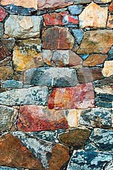 Stone wall texture background. Old outdoor rocks surface of a medieval fortress. Close-up natural rustic pattern.
