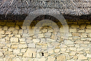 Stone wall under the thatched roof
