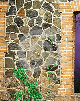 stone wall with a window and a green grass
