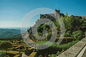 Stone walls and tower of Castle with lush flowered garden