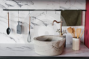 Stone washbasin with vintage mixer on marble kitchen background