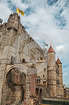 Stone watch-tower, walls and flags inside the Gravensteen Castle at Ghent.