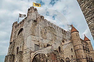 Stone watch-tower, walls and flags inside the Gravensteen Castle at Ghent.