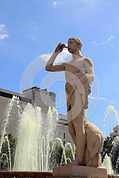 Stone water fountain with piper statue in Barcelona, Spain