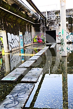 Stone way through water on a Lost Place with Graffiti