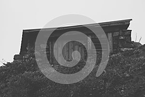 Stone wood shed in hillside from front black and white