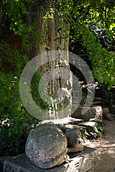 Stone worship stele and sculture. Japanese garden in Daifazu, Kyushu, Japan.