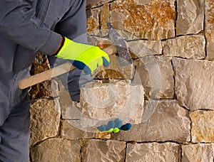 Stonecutter mason with hammer and stone working masonry photo