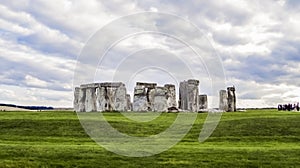 Stonehenge prehistoric monument, green grass, clouds, panoramic view - Wiltshire, Salisbury, England