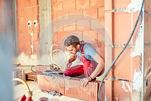 Stonemason building walls, construction engineer and worker on site