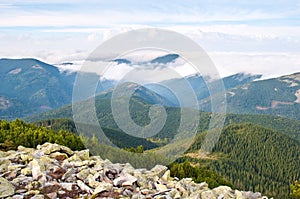 Stones against the hill covered with white clouds