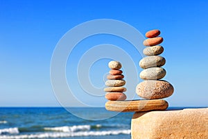 Stones balance on a background of blue sky and sea