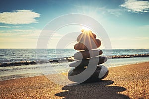 Stones balance on the beach during sunrise. Zen meditation.