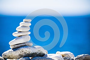Stones balance, pebbles stack over blue sea in Croatia.