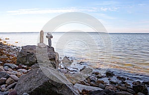 Stones balance, zen pebbles stack over blue sea in Estonia. Blue sky on sunny coast in summer.