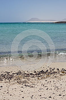 Stones on a beach breaking wave Lobos Island Corralejo, Fuerteventura.