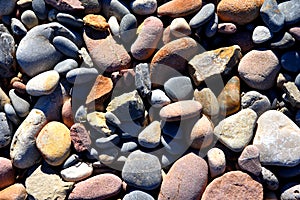 Stones on beach. Decorative texture of stones. Sea stones background. Colored stone on coastline