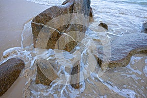 Stones on the beach that are rolling waves