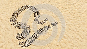 Stones on beach sand handmade symbol shape, golden sandy background, libra zodiac sign