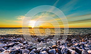 Stones on a beach with sunset on the ocean sea.