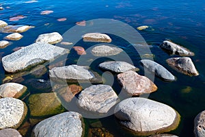 Stones in clear blue lake water. Lake Ladoga, Russia