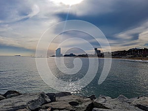 Stones cliffs rocks front hotel w promenade beach Barcelona walk sunshine Barcelonetta tourist sea ocean mirror water