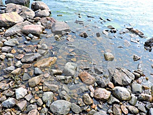 Stones on the coast of blue Baltic sea, island Suomenlinna, Helsinki