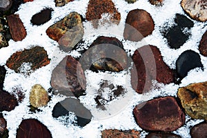 Stones covered by the snow. Abstract winter background.