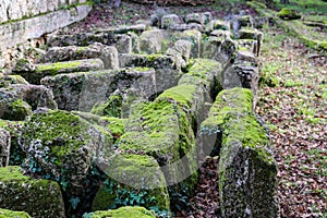 Stones found and placed by archeologists at the ancient site of Olympia on the Peloponnese peninsula in Southern Greece overgrown