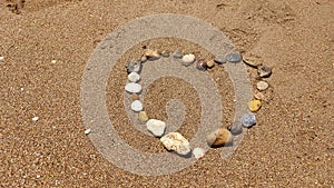 Stones in heart shape laid out by hand on sand of sesa beach
