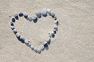 Stones in heart shape on sand