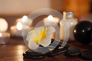 Stones for hot massage are prepared on the table along with burning candles