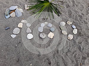 Stones on a large sand laid out the name of a resort town in Russia, translated from Russian - Loo