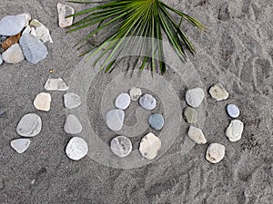 Stones on a large sand laid out the name of a resort town in Russia, translated from Russian - Loo