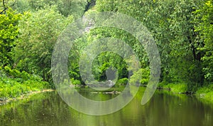 Stones near old rusty dam on a river at cloudy sky