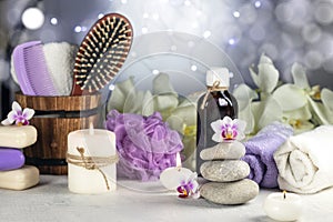 Stones, orchid flowers, burning candles, towel, massage oil, soap, washcloths, combs, abstract lights. Spa resort therapy