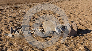 Stones pebbles and slates in a circle on beach