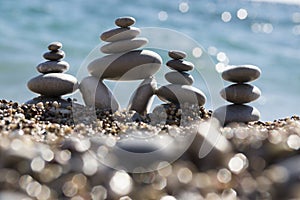 Stones and pebbles stack, harmony and balance, three stone cairns on seacoast with ocean waves