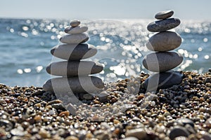 Stones and pebbles stack, harmony and balance, two stone cairns on seacoast