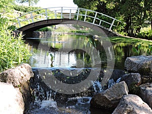 Stones, pond, water cascade and white bridge  in  the park, Karhula, Finland