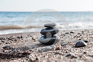 Stones pyramid on the beach, sea in the background