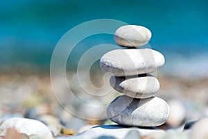 Stones pyramid on pebble beach with blur sea background. Travel and relax concept