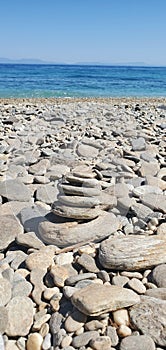 Stones pyramid on pebble beach symbolizing stability, zen, harmony, balance