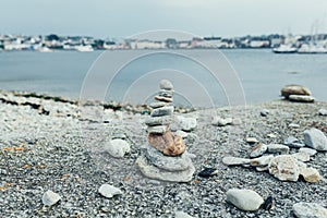 Stones pyramid on pebble beach symbolizing stability, zen, harmony, balance. Shallow depth of field.