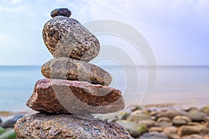 Stones pyramid on the seashore. Sunset on pebble beach. Balanced life, relax