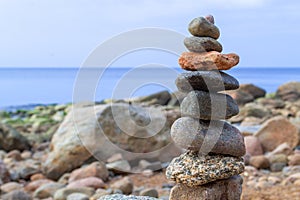 Stones pyramid on the seashore. Sunset on pebble beach. Balanced life, relax.