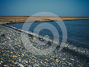 Stones and rubbish on Atlantic Ocean shore