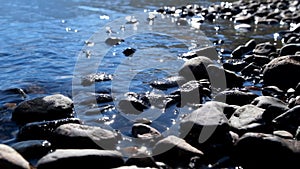 Stones on the shallow water of Lower Multinskoe lake in Altai