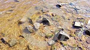 Stones in transparent water. sea waves approaching the rocky shore. water surface with ripples